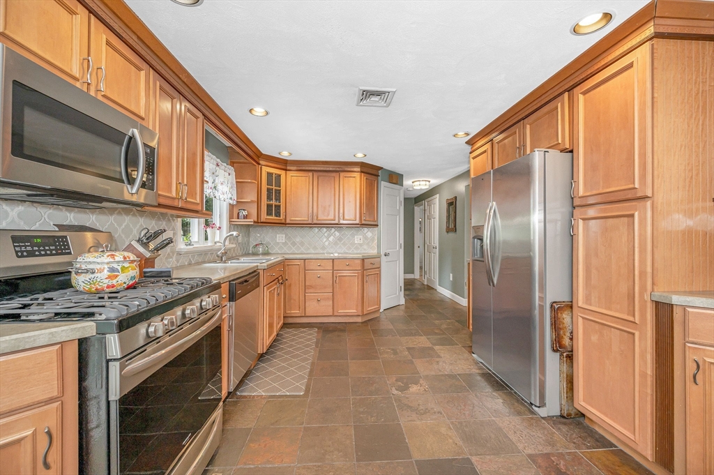 180 Foster Road Tewksbury, MA 01876 - Photo 8 of 38 a kitchen with stainless steel appliances granite countertop a refrigerator a stove and a sink