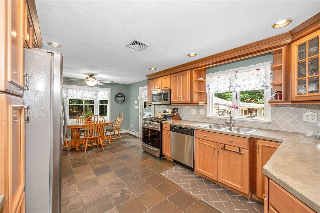 180 Foster Road Tewksbury, MA 01876 - Photo 9 of 38 a large kitchen with kitchen island granite countertop a large window cabinets and stainless steel appliances