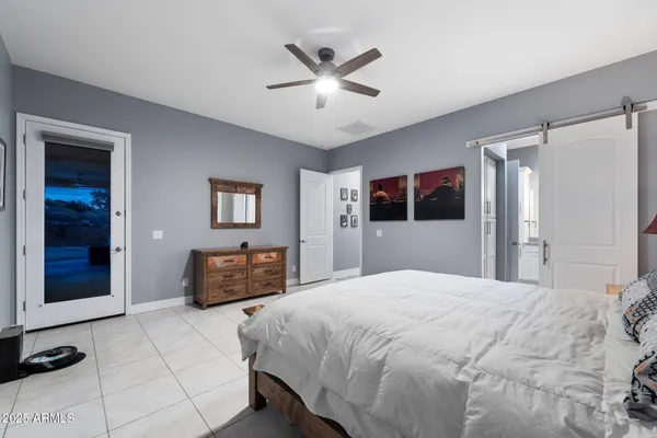 a bedroom with a large bed and a chandelier
