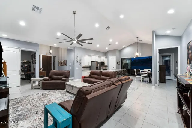 a living room with furniture kitchen and a chandelier