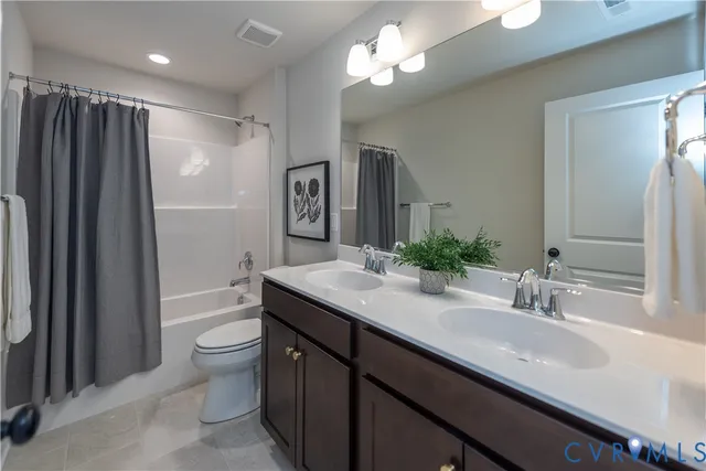 a bathroom with a double vanity sink toilet mirror and shower
