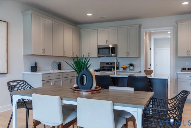 a kitchen with a dining table cabinets and appliances