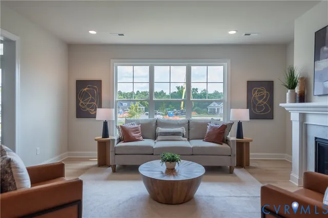 a living room with furniture a fireplace and a large window