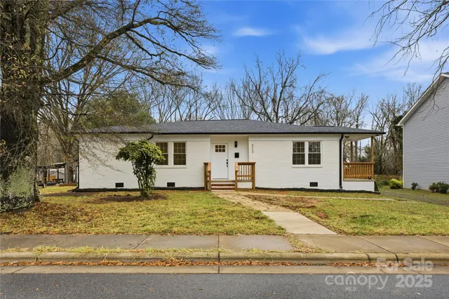 a view of a house with a big yard and a garage