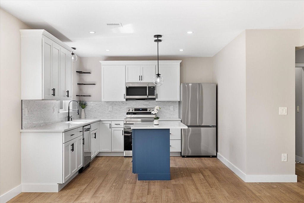 6 Eagleton Street Spencer, MA 01562 - Photo 12 of 36 a kitchen with stainless steel appliances granite countertop a refrigerator a stove top oven a sink and dishwasher with wooden floor