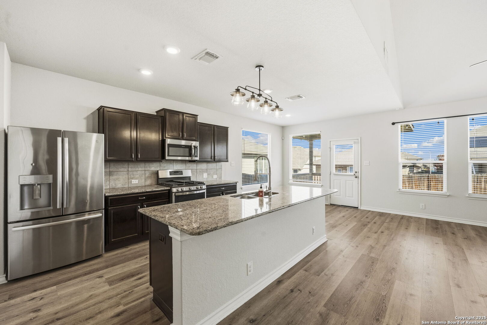 328 Swift Move Cibolo, TX 78108 - Photo 11 of 32 a large kitchen with granite countertop a large counter top stainless steel appliances and wooden floor