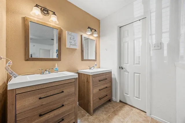a bathroom with a double vanity sink mirror and