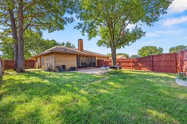 a view of a house with backyard and a tree