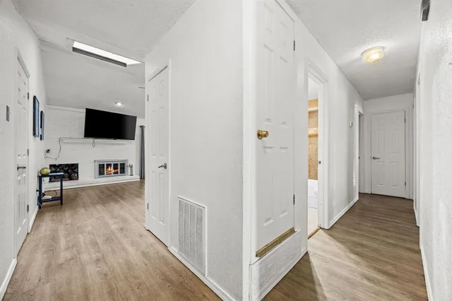 a view of a hallway with wooden floor and a fireplace