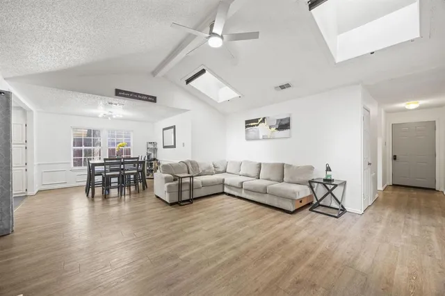 a living room with furniture and a wooden floor