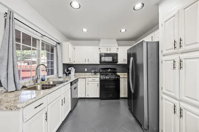a kitchen with stainless steel appliances granite countertop a refrigerator and a sink