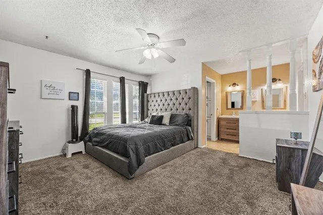 a spacious bedroom with a large bed and a chandelier