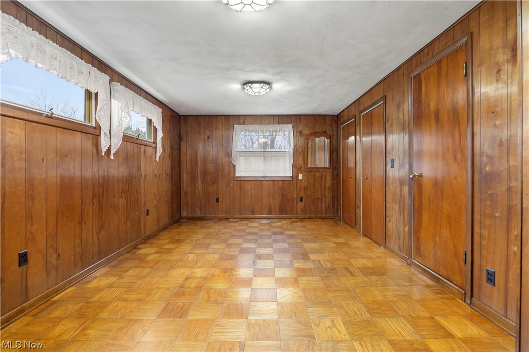 41555 Butternut Ridge Road Elyria, OH 44035 - Photo 35 of 44 Empty room featuring light parquet flooring and wooden walls
