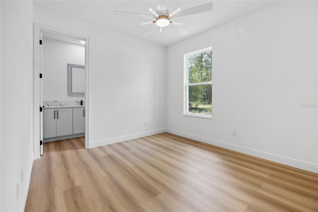 9789 Southwest 125th Ct Road Dunnellon, FL 34432 - Photo 19 of 37 wooden floor in an empty room with a window