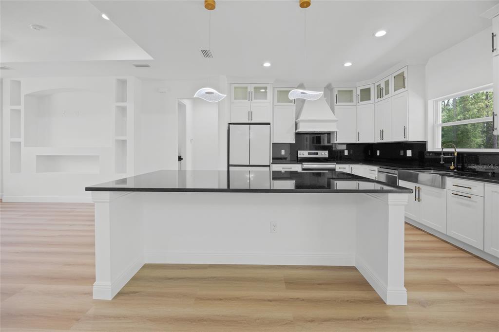 9789 Southwest 125th Ct Road Dunnellon, FL 34432 - Photo 10 of 37 a kitchen with stainless steel appliances granite countertop a stove a sink and white cabinets