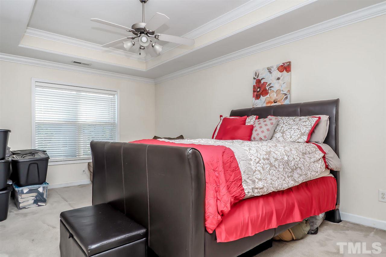 2112 Stoney Spring Drive Raleigh, NC 27610 - Photo 15 of 25 a bedroom with a bed and a chandelier