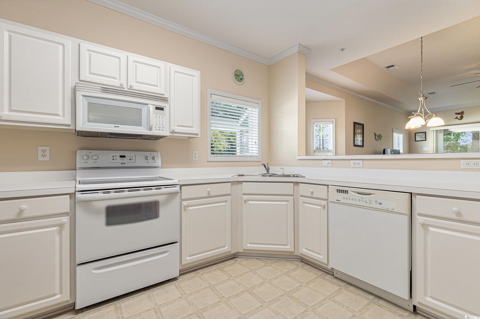 730 Charter Drive, Unit F11 Longs, SC 29568 - Photo 12 of 32 Kitchen with white appliances, light countertops, ornamental molding, white cabinetry, and light floors