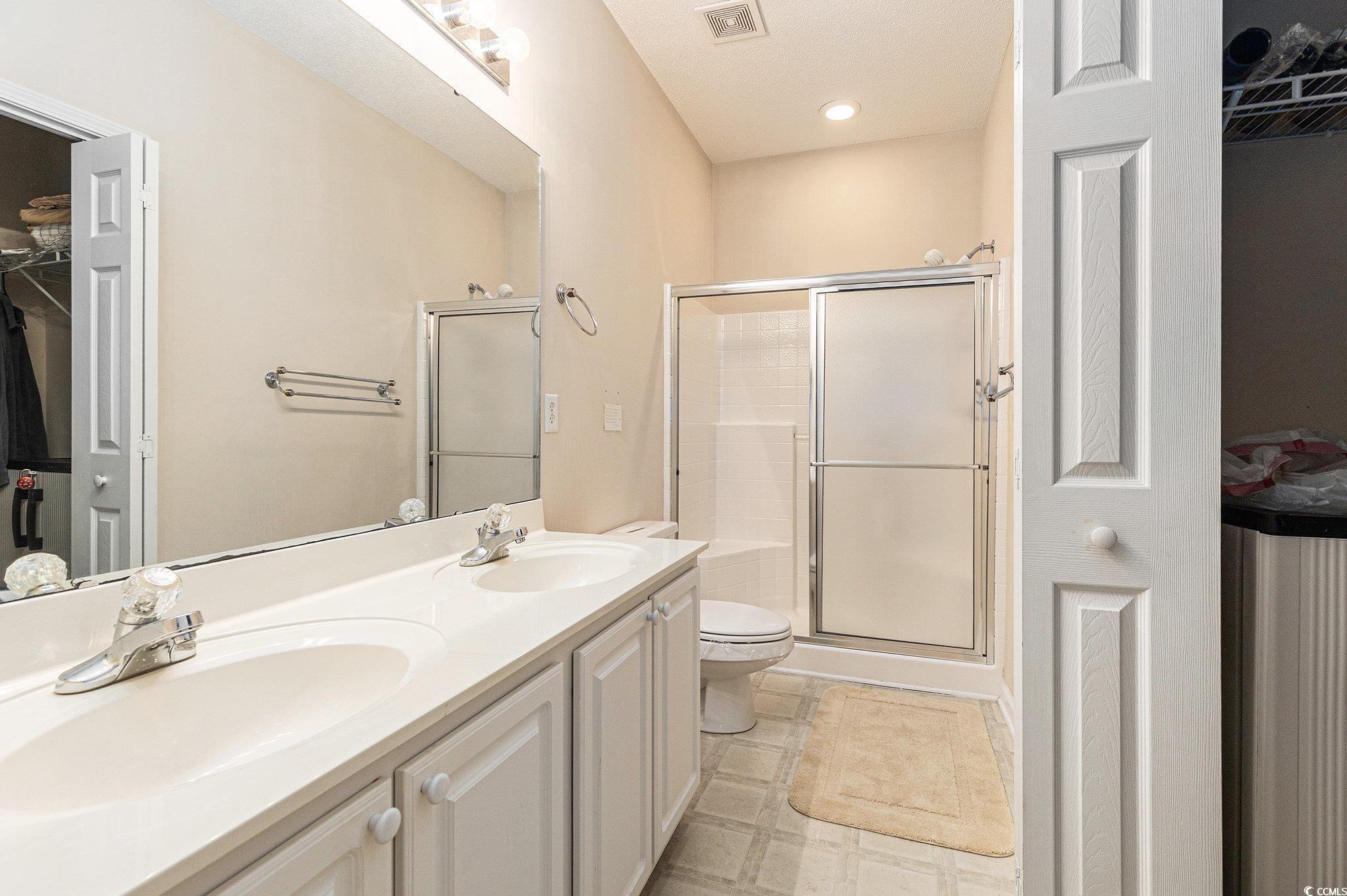 730 Charter Drive, Unit F11 Longs, SC 29568 - Photo 19 of 32 Bedroom featuring light carpet, vaulted ceiling, and ensuite bath