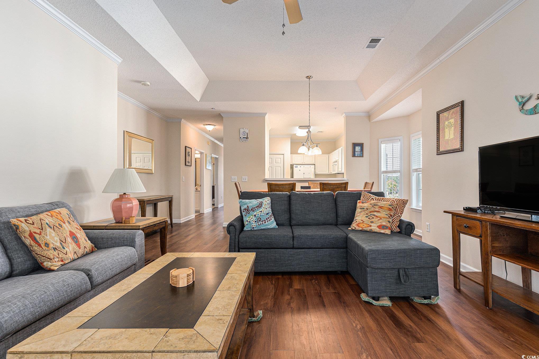 730 Charter Drive, Unit F11 Longs, SC 29568 - Photo 6 of 32 Living area featuring a raised ceiling, crown molding, dark wood-style flooring, and ceiling fan