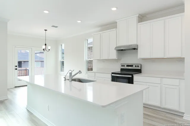 a kitchen with stainless steel appliances granite countertop a sink a stove and a refrigerator