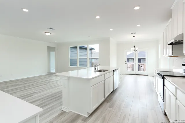 a large kitchen with stainless steel appliances granite countertop a large counter top a sink and a stove