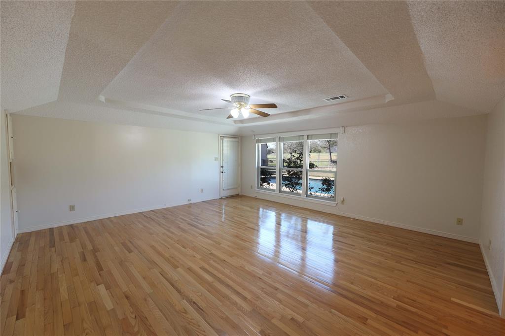 907 Red Oak Creek Road Ovilla, TX 75154 - Photo 14 of 20 Spacious room featuring wood-finish flooring and a tray ceiling with a ceiling fan
