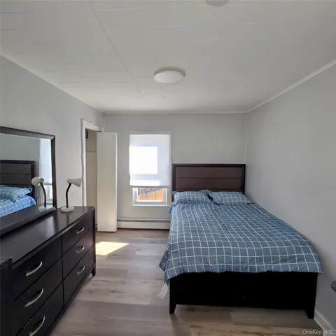 a bedroom with a bed and flat tv screen on a dresser