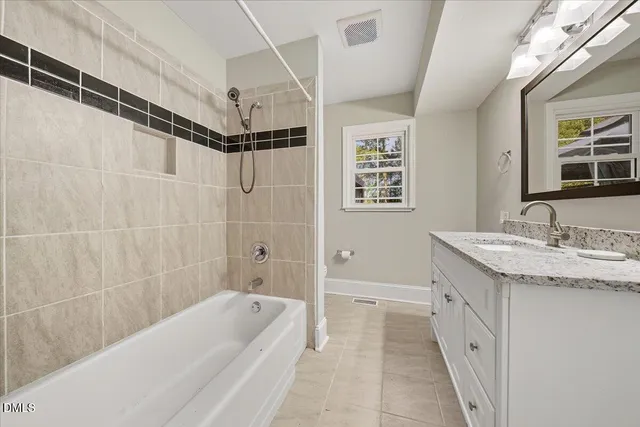 a bathroom with a granite countertop sink a toilet a shower and a bathtub