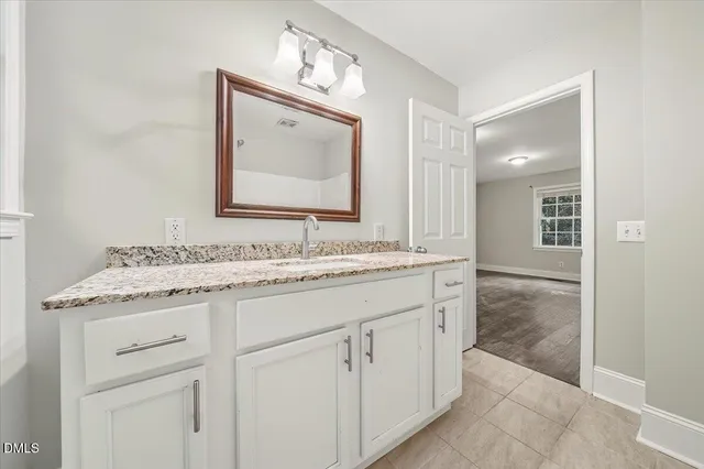 a bathroom with a granite countertop sink vanity and mirror