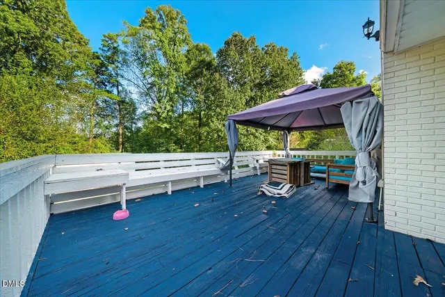 a backyard of a house with wooden floor and outdoor seating