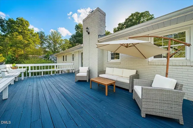 a view of a deck with table and chairs with wooden floor and fence