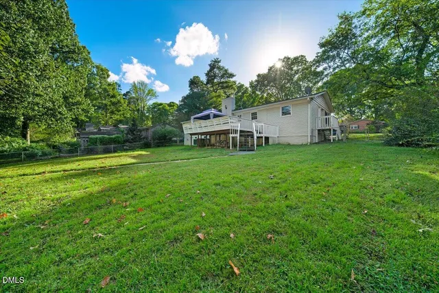 a view of a house with a big yard and large trees
