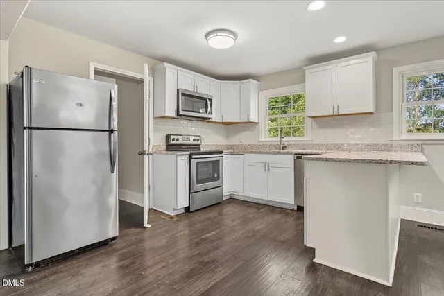 a kitchen with stainless steel appliances a refrigerator sink and microwave