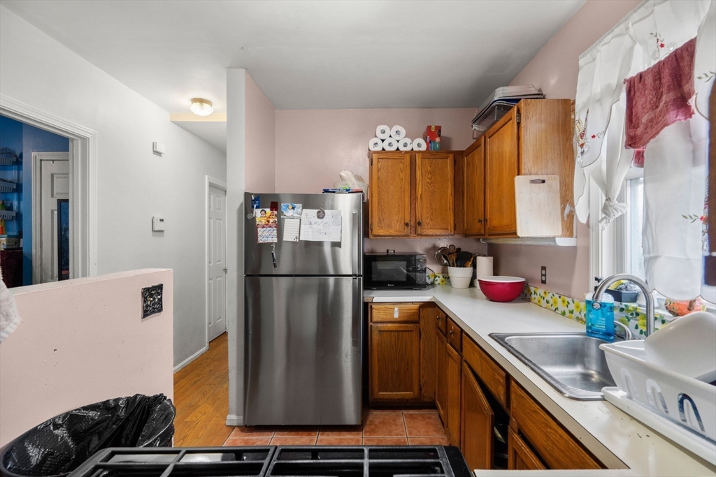 90 Timson Street Lynn, MA 01902 - Photo 14 of 38 a kitchen with a refrigerator and a stove top oven