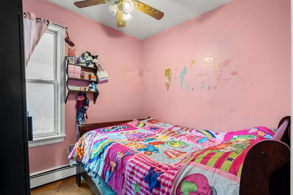 90 Timson Street Lynn, MA 01902 - Photo 15 of 38 a bedroom with a bed and a chandelier