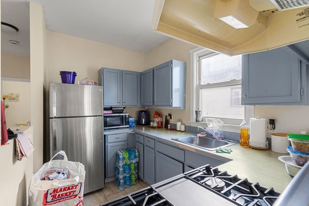 90 Timson Street Lynn, MA 01902 - Photo 24 of 38 a kitchen with a refrigerator and a stove top oven