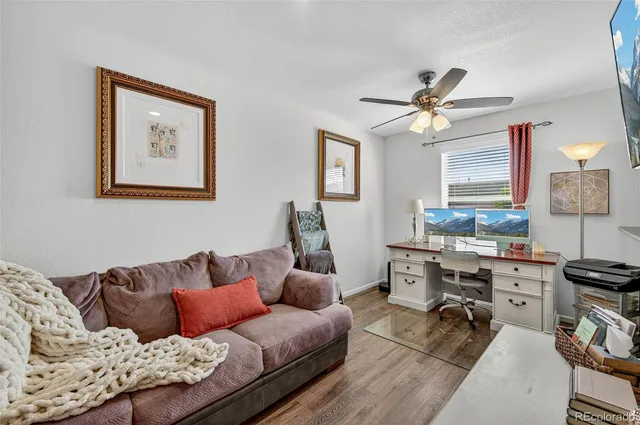 a living room with furniture kitchen view and a window
