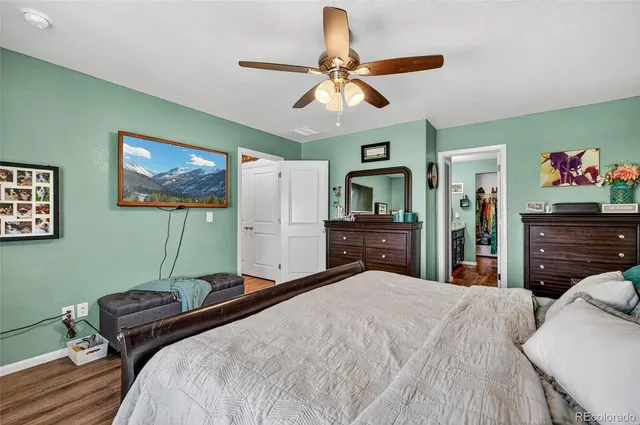 a bedroom with a large bed a chandelier and dresser