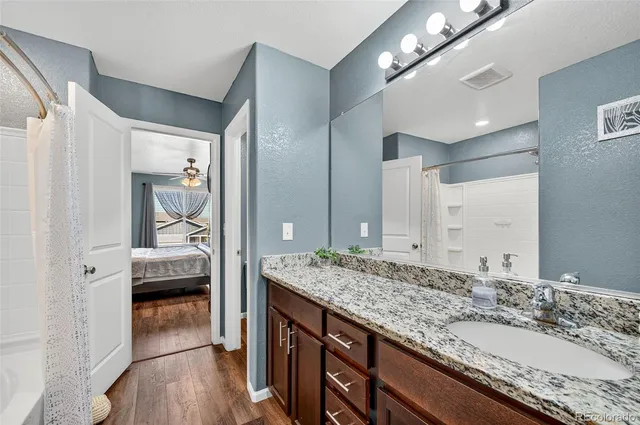a bathroom with a granite countertop double vanity sink and a mirror