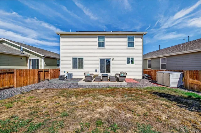 a view of a house with backyard and sitting area