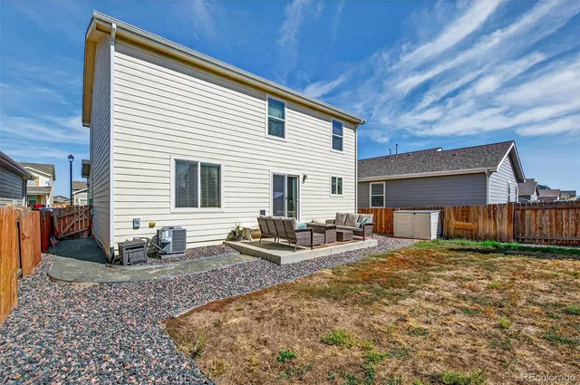 a view of a house with backyard and sitting area