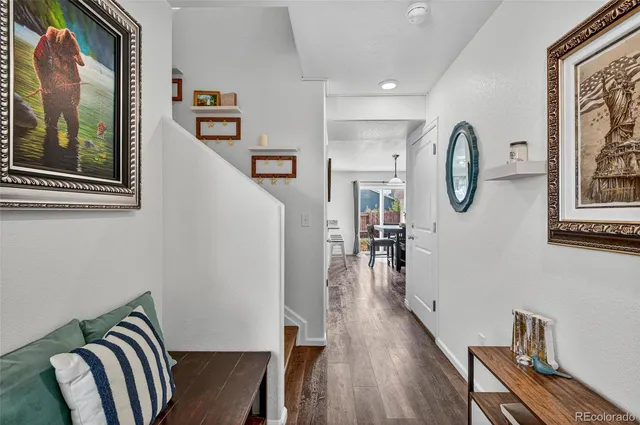 a view of a hallway with wooden floor and staircase