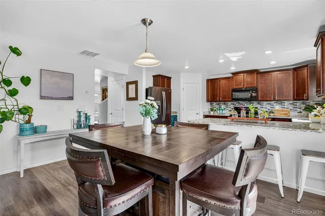 a kitchen with a table chairs refrigerator and microwave