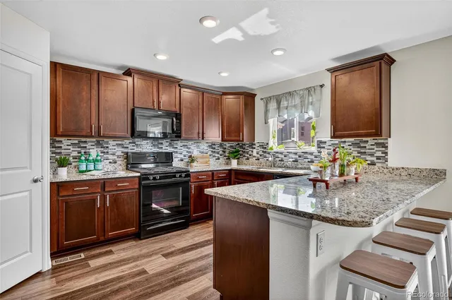 a kitchen with stainless steel appliances granite countertop a sink stove and cabinets