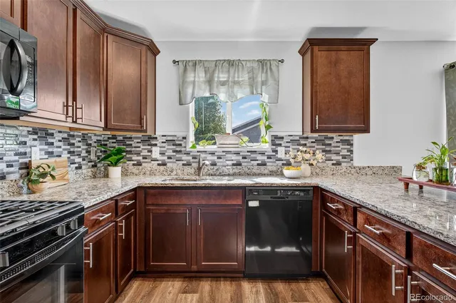 a kitchen with stainless steel appliances granite countertop a sink stove and cabinets