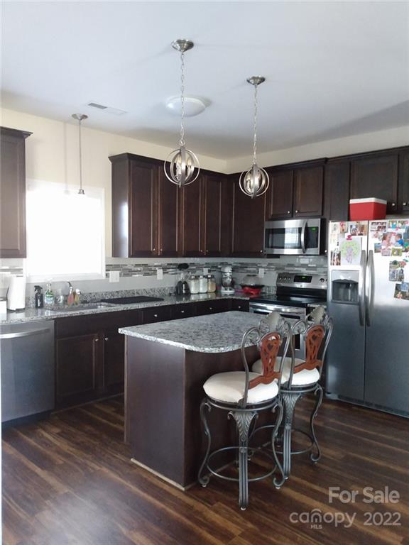 1114 Turtle Ridge Drive Monroe, NC 28110 - Photo 7 of 7 a kitchen with stainless steel appliances granite countertop a stove top oven a refrigerator a sink and chairs