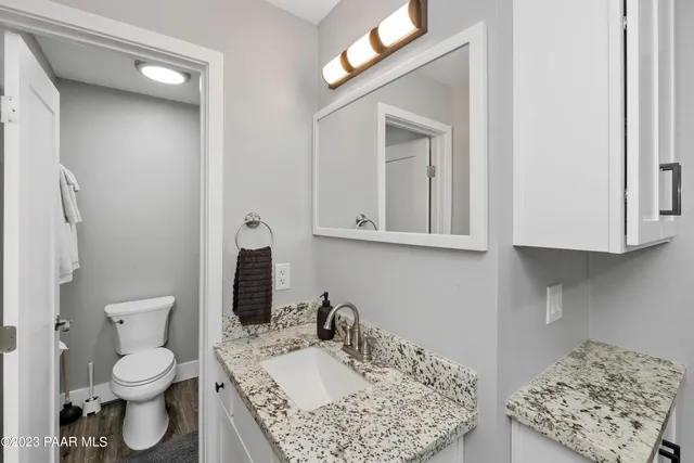 a bathroom with a granite countertop sink and a mirror