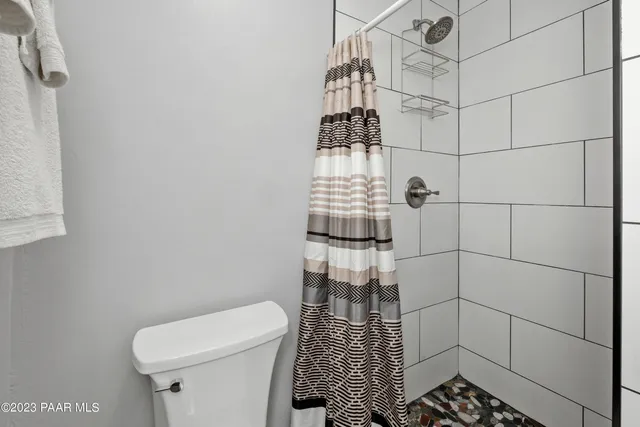 a bathroom with a toilet and a shower
