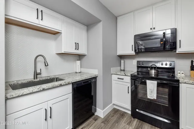 a kitchen with stainless steel appliances granite countertop a stove a sink and a microwave