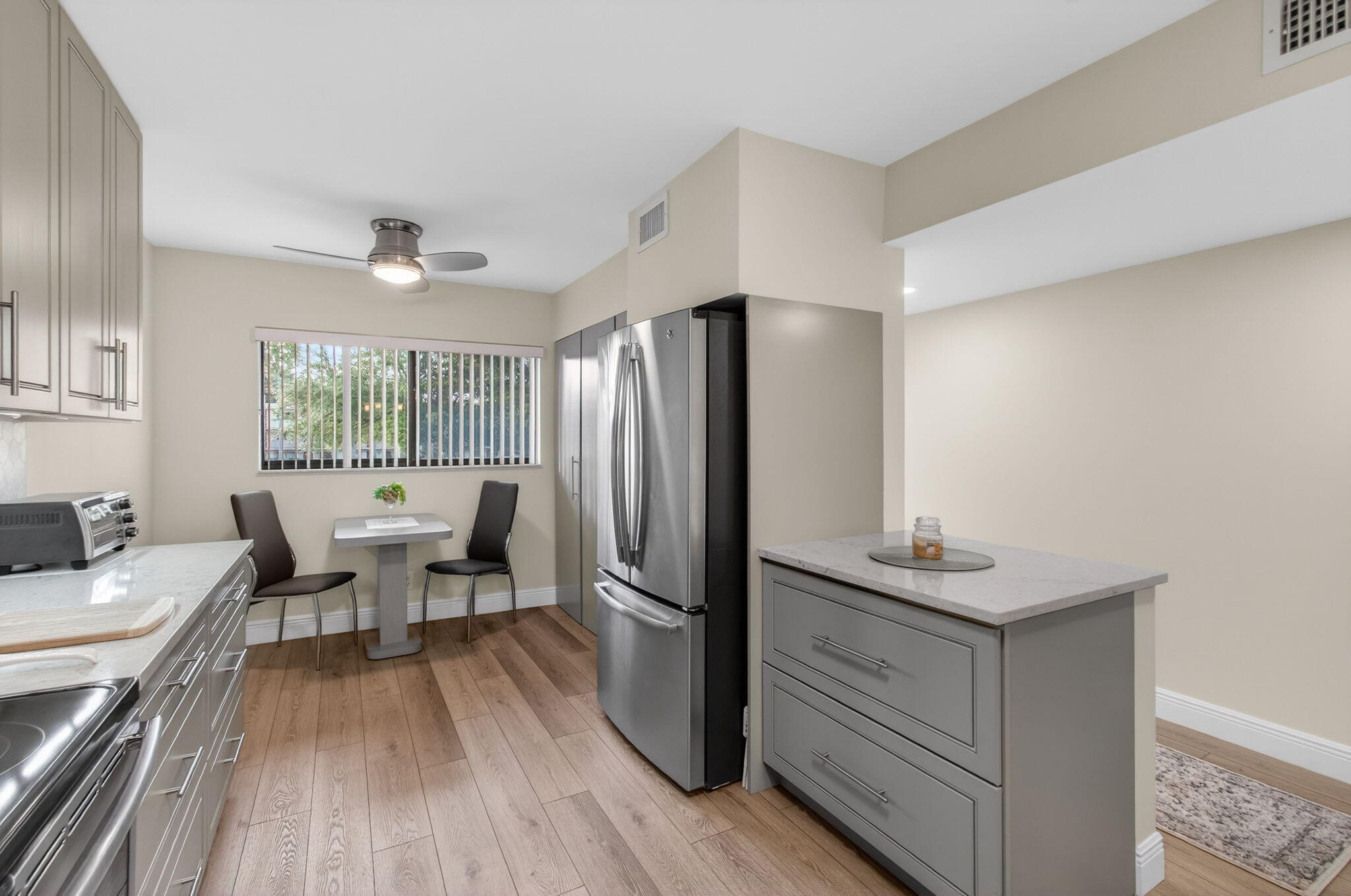 15074 Witney Road, Unit 204 Delray Beach, FL 33484 - Photo 21 of 56 a kitchen with a table chairs refrigerator and cabinets